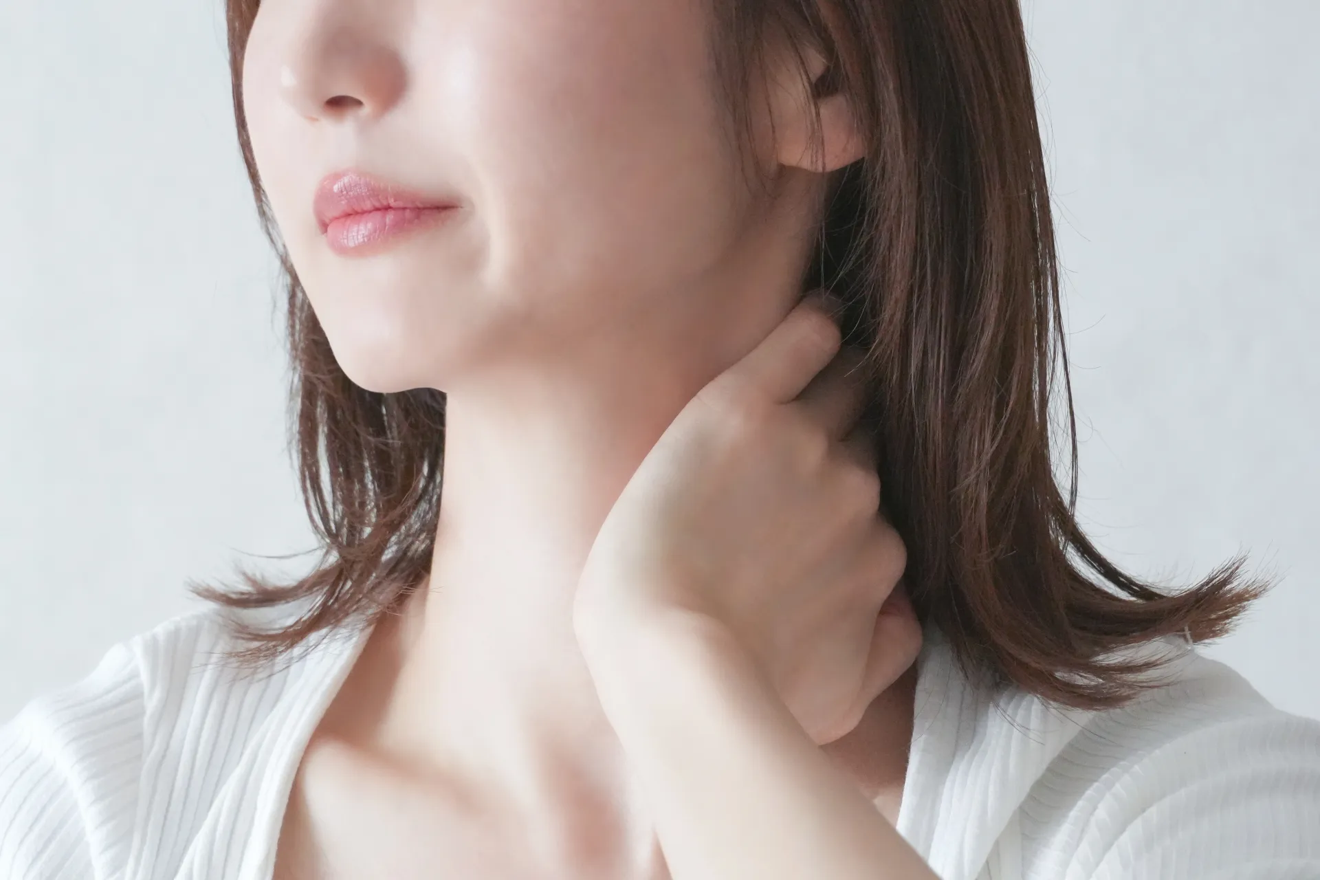 首、肩の痛みに悩む女性