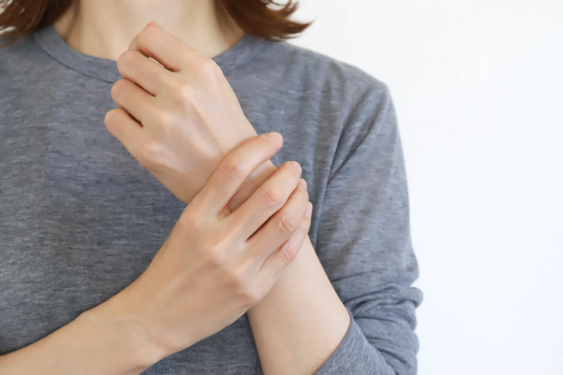 手の痺れに悩む女性